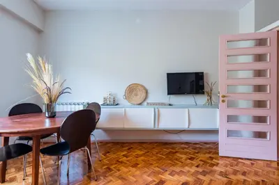 a dining room with a table and chairs and a tv at AMAZING DUPLEX - Mid Century Experience & PARKING in Porto