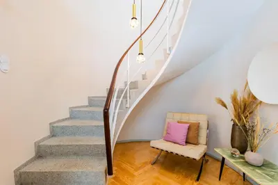 a room with a staircase with a chair and a table at INCREDIBLE DUPLEX PENTHOUSE & TERRACES & Parking in Porto