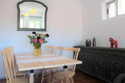 a dining room table with a vase of flowers on it at Pilar home in Vila Nova de Gaia