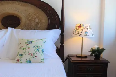 a bed with a pillow and a lamp on a night stand at Pilar home in Vila Nova de Gaia