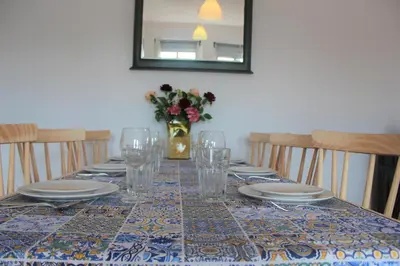 a table with plates and glasses and a vase with flowers at Pilar home in Vila Nova de Gaia