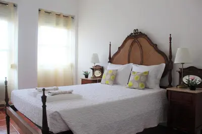 a bedroom with a large bed with a wooden headboard at Pilar home in Vila Nova de Gaia