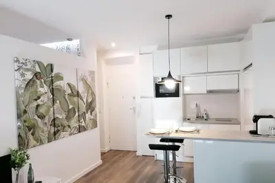 a white kitchen with a large painting on the wall at Window Garden Apartment in Porto