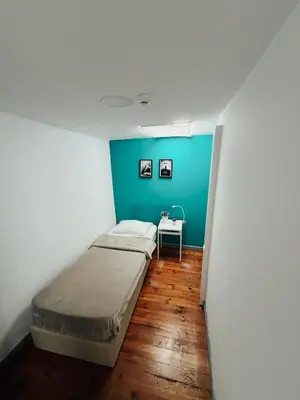 a bedroom with a bed and two plants on a table at By Doors Hostel in Porto
