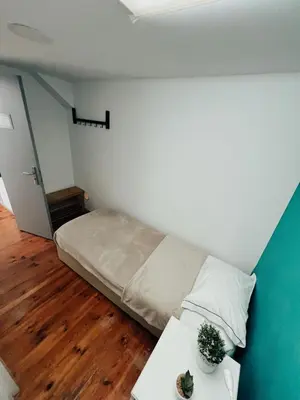 a bed with a towel laying on the floor at By Doors Hostel in Porto