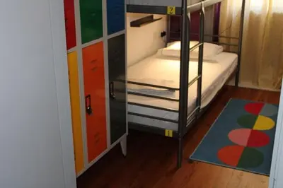 a bedroom with a bed with pink walls and a window at By Doors Hostel in Porto