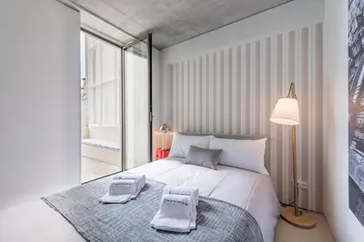 a bedroom with a large bed with two towels on it at Cedofeita Lux Design in Porto