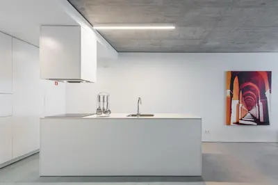 a white kitchen with a sink and a painting at Cedofeita Lux Design in Porto