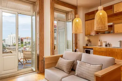 a kitchen and living room with a table and a couch at Tripas-Coração, Cordoaria River View, Garden View or Loft in Porto