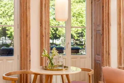 a table with a vase of flowers on top at Tripas-Coração, Cordoaria River View, Garden View or Loft in Porto
