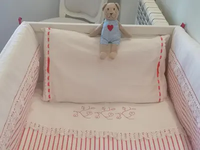 a teddy bear laying on a pillow in a crib at Architect House in Porto