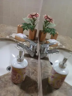a bathroom with two faucets and a sink with flowers at Architect House in Porto