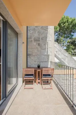 a patio with a table and chairs on a balcony at Liiiving in Porto - Charming Downtown Delight in Porto