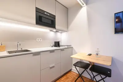 a bedroom with a white bed and a large window at Sleep in Office in Porto
