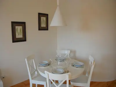 a white dining room table with white chairs and plates at Top Flat in Porto