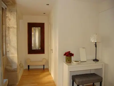 a hallway with a fireplace and a chair and a mirror at Top Flat in Porto