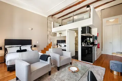 a bedroom with a king sized bed and two chairs at Maison Cabral in Porto