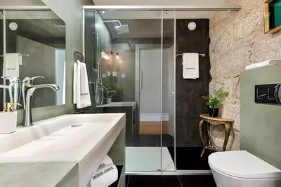 a bathroom with a sink and a toilet and a shower at Maison Cabral in Porto