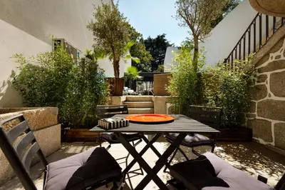 a patio with a table and chairs on a patio at Maison Cabral in Porto