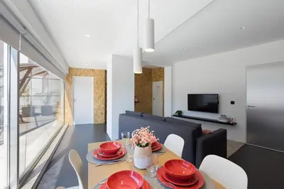 a dining room with a table and chairs and a television at QP Trindade Apartments in Porto