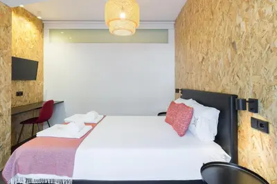 a hotel room with a bed and a chair at QP Trindade Apartments in Porto