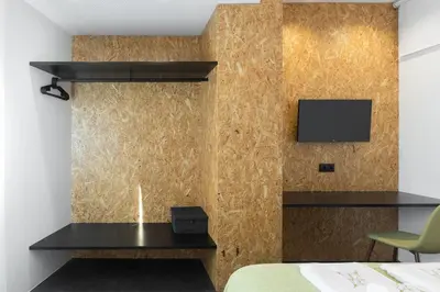 a bedroom with a desk and a television on a wall at QP Trindade Apartments in Porto