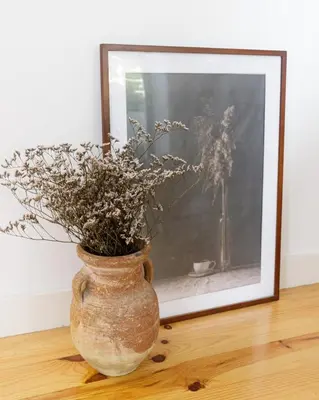 a vase with flowers in it sitting in front of a picture at Relax Porto Studio by Own Places in Porto