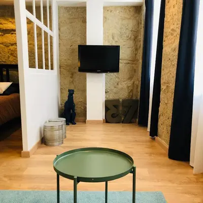 a room with a table and a tv on a wall at Boreal Porto Gaia - Patio & Pool in Vila Nova de Gaia