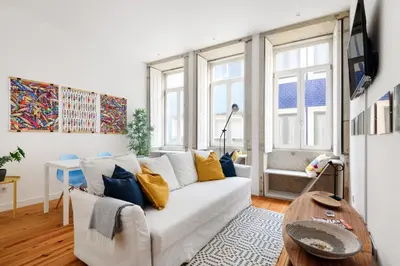 a living room with a white couch and some windows at Spacious Duplex in Porto's Downtown • A/C in Porto