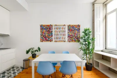 a dining room with a white table and blue chairs at Spacious Duplex in Porto's Downtown • A/C in Porto