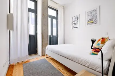 a bedroom with a bed and two windows at Spacious Duplex in Porto's Downtown • A/C in Porto