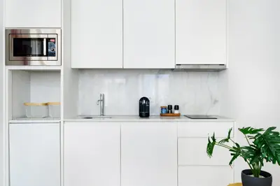 a white kitchen with a sink and a microwave at Spacious Duplex in Porto's Downtown • A/C in Porto
