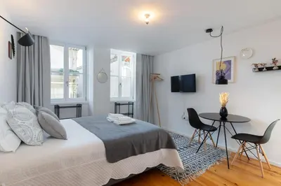 a bedroom with a bed and a table and chairs at Porto Historical Center Apartments in Porto