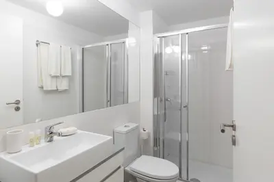 a white bathroom with a toilet and a shower at Porto Historical Center Apartments in Porto