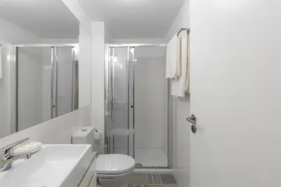 a white bathroom with a shower and a toilet at Porto Historical Center Apartments in Porto