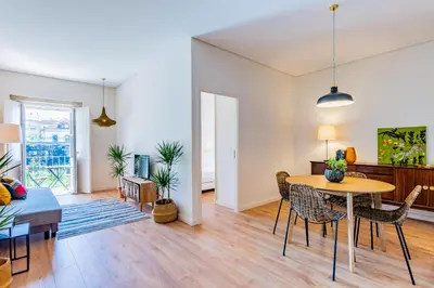 a living room with a table and chairs and a couch at Boavista Garden Apartment in Porto