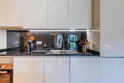 a kitchen with white cabinets and a sink at Boavista Garden Apartment in Porto