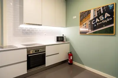 a kitchen with white cabinets and a stove at VIVA Size Flats Clérigos in Porto