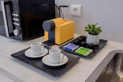 a tray with two cups and a coffee maker on a kitchen counter at Plaza-Charming GuestHouse in Porto