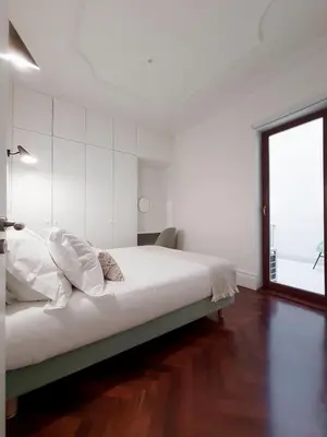 a white bedroom with a large bed and a window at Trindade Premium Apartments in Porto
