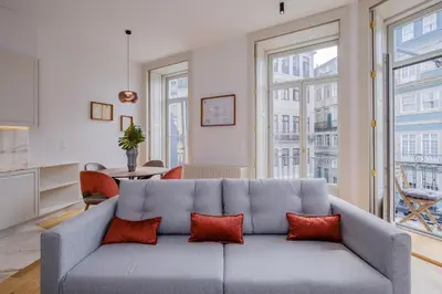 a living room with a gray couch with red pillows at BOUTIQUE Rentals-Kihara’s Ribeira Apt with great views in Porto