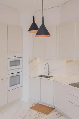 a white kitchen with a sink and two pendant lights at BOUTIQUE Rentals-Kihara’s Ribeira Apt with great views in Porto
