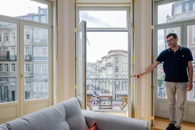 a man standing in a room looking out of a window at BOUTIQUE Rentals-Kihara’s Ribeira Apt with great views in Porto