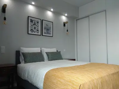 a bedroom with a bed with white sheets and green pillows at Chez Moi Bolhão in Porto
