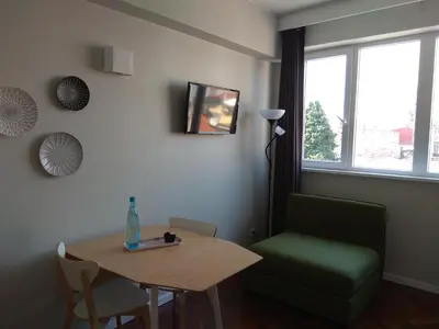 a living room with a table and a green chair at Chez Moi Bolhão in Porto