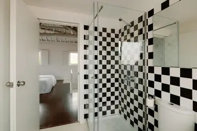 a bathroom with a black and white checkered wall at Fine Arts Studios by Olala Homes in Porto
