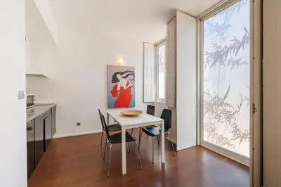 a kitchen and dining room with a white table and chairs at Fine Arts Studios by Olala Homes in Porto