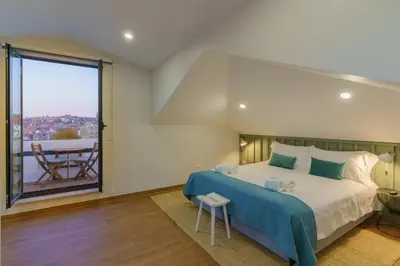 a bedroom with a large bed and a balcony at Feel Porto Wine Essence Apartments in Vila Nova de Gaia