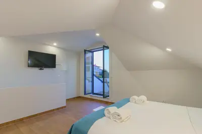 a bedroom with a bed and a tv on a wall at Feel Porto Wine Essence Apartments in Vila Nova de Gaia