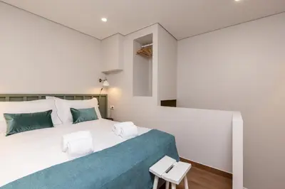 a bedroom with a large bed with a blue blanket at Feel Porto Wine Essence Apartments in Vila Nova de Gaia